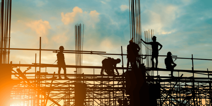Silhouette of engineer and construction team working safely on scaffolding on high rise building.