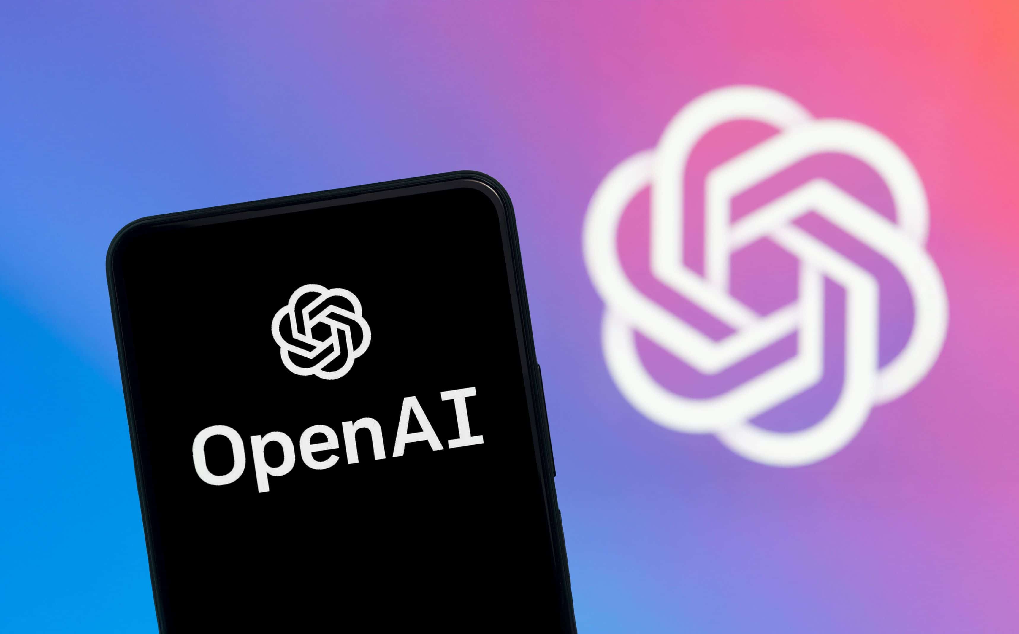 Smartphone screen displaying the OpenAI logo with the OpenAI emblem blurred in the background